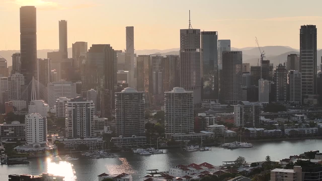 Metropolitan area of Brisbane city centre with tall buildings during warm sunset. Drone aerial