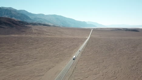 aerial shot of cars driving on desert highway in death valley national park, california