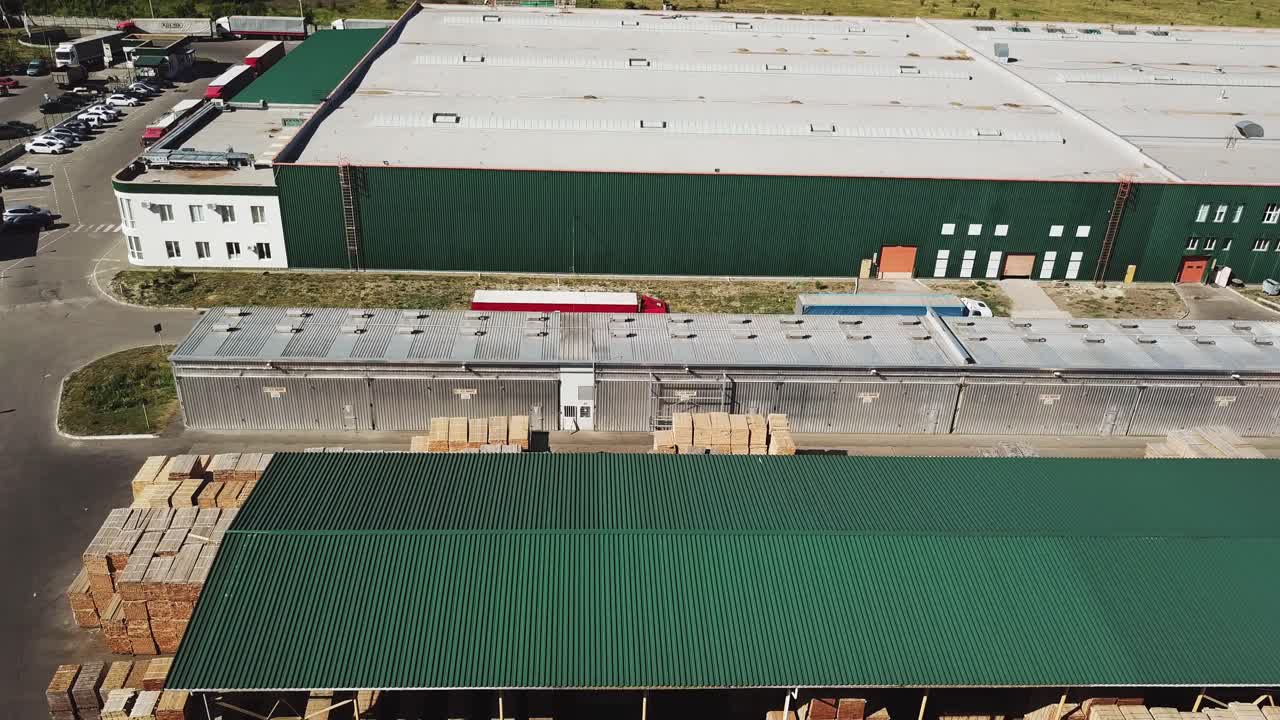 The territory of the warehouse and the factory with parquet. Wood processing plant. Aerial view. Camera motion to left