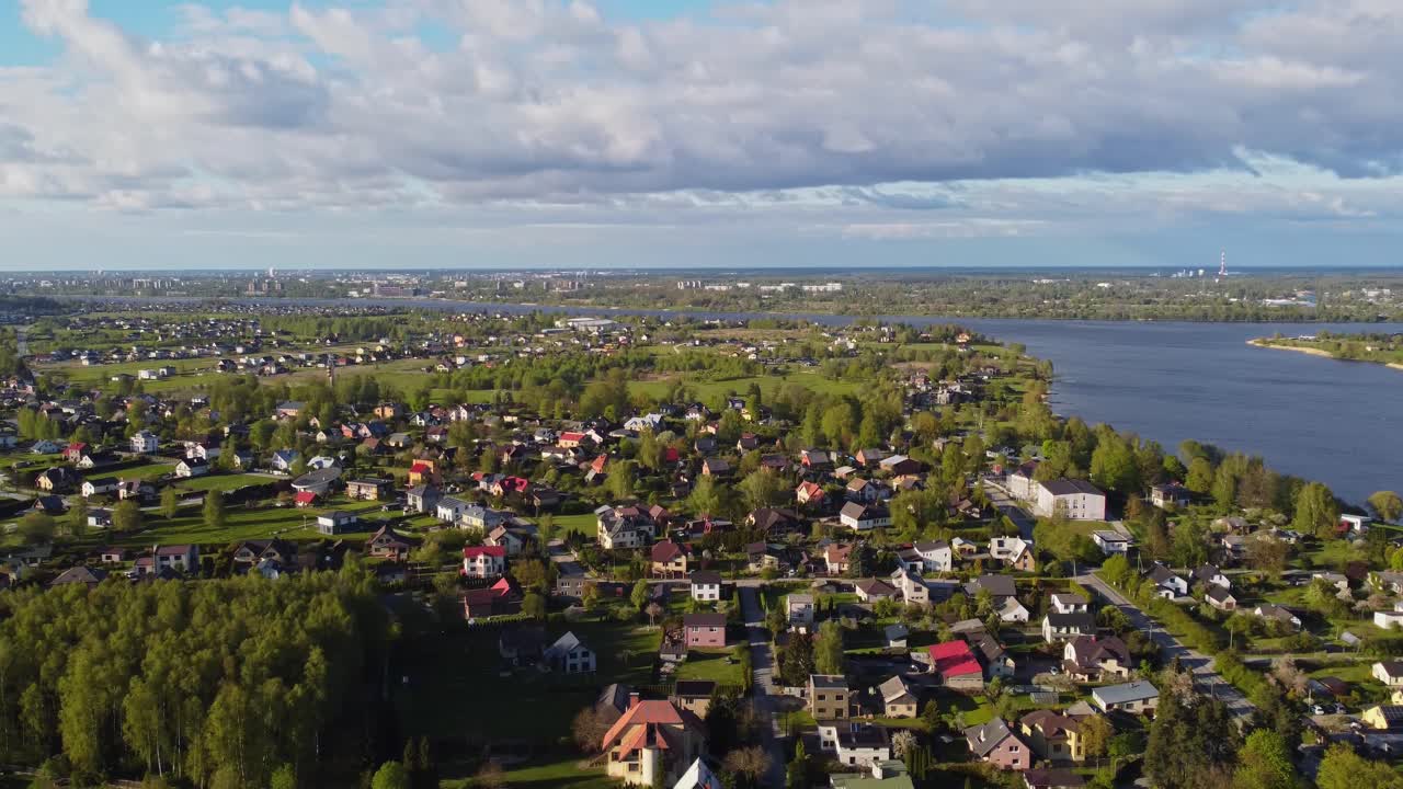 Katlakalns Spring neighborhood in sunshine, located near a big scenic river and green space.