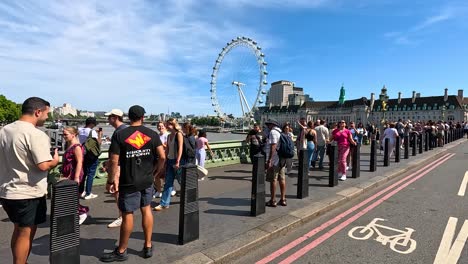 people gathered on bridge near london eye