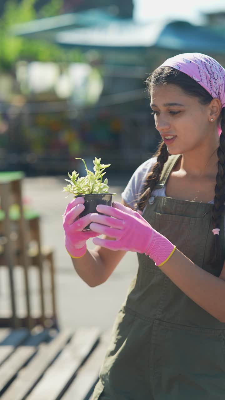 joven inspeccionando una planta en un centro de jardinería