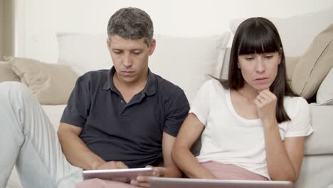 Family-couple-sitting-together-on-apartment-floor