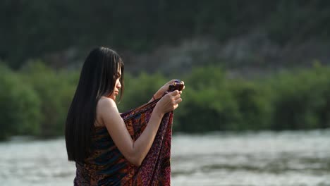 woman in traditional clothing by a river