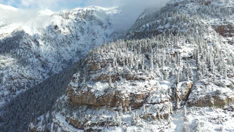 Drohnenaufnahme-Von-Schneebedeckten-Berggipfeln-Und-Klippen-An-Sonnigen-Wintertagen,-Drohnenaufnahme