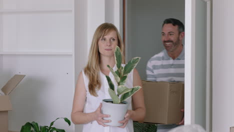 young-couple-moving-house-new-home-owners-smiling-enjoying-successful-move-embracing-in-apartment