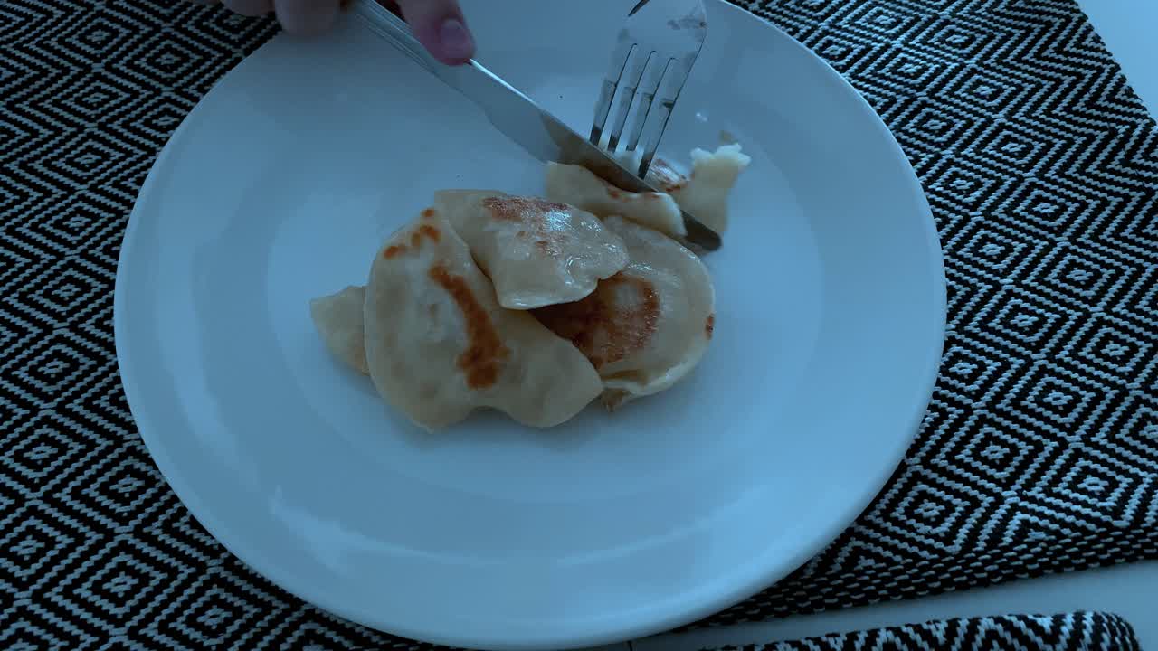 Front view slicing dumplings by knife on white plate, home made dumplings
