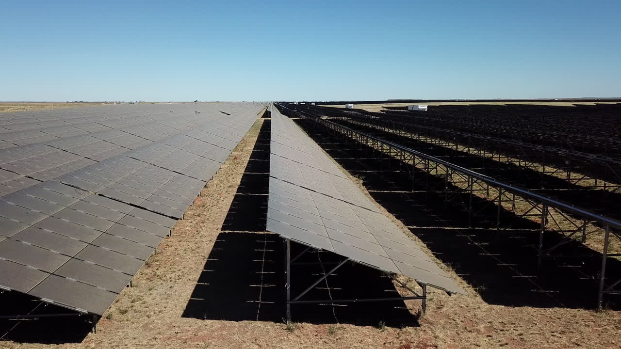 paneles solares en un paisaje desértico parecido a marte durante el mediodía desde un dron de ángulo bajo