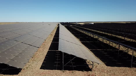 paneles solares en un paisaje desértico parecido a marte durante el mediodía desde un dron de ángulo bajo