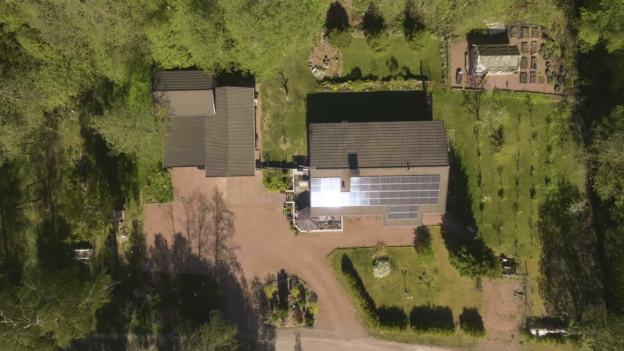 Birds eye drone shot above a house with reflecting solar cells, sunny, summer day