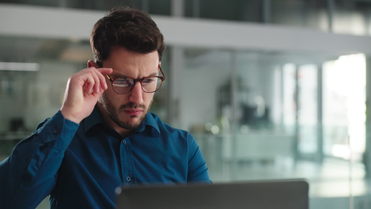 Man with glasses working on a computer