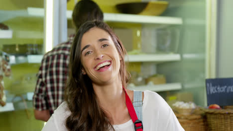 personal femenino sonriente de pie con la mano en la cadera en la sección orgánica