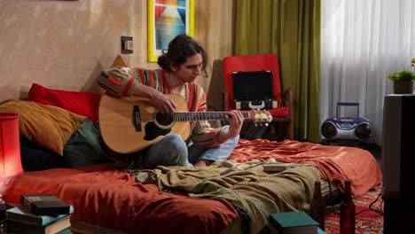 man playing acoustic guitar in a retro bedroom