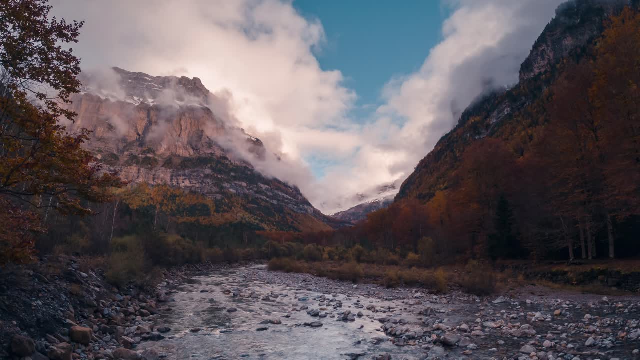 Ordesa national park valley mountains and river on a cloudy and misty winter afternoon timelapse of clouds rolling over mountain peaks in fall autumn season
