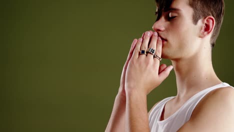 Androgynous-man-posing-against-green-background