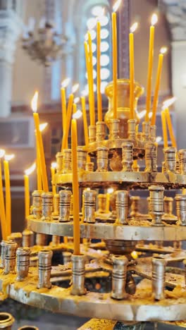 hand placing a votive candle in a greek church