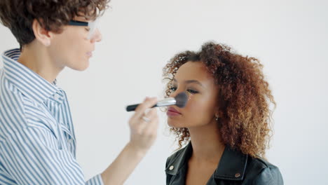 makeup artist applying makeup to model