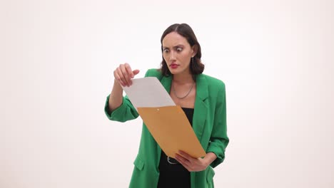 woman reacts with surprise and shock while reading a document from an envelope