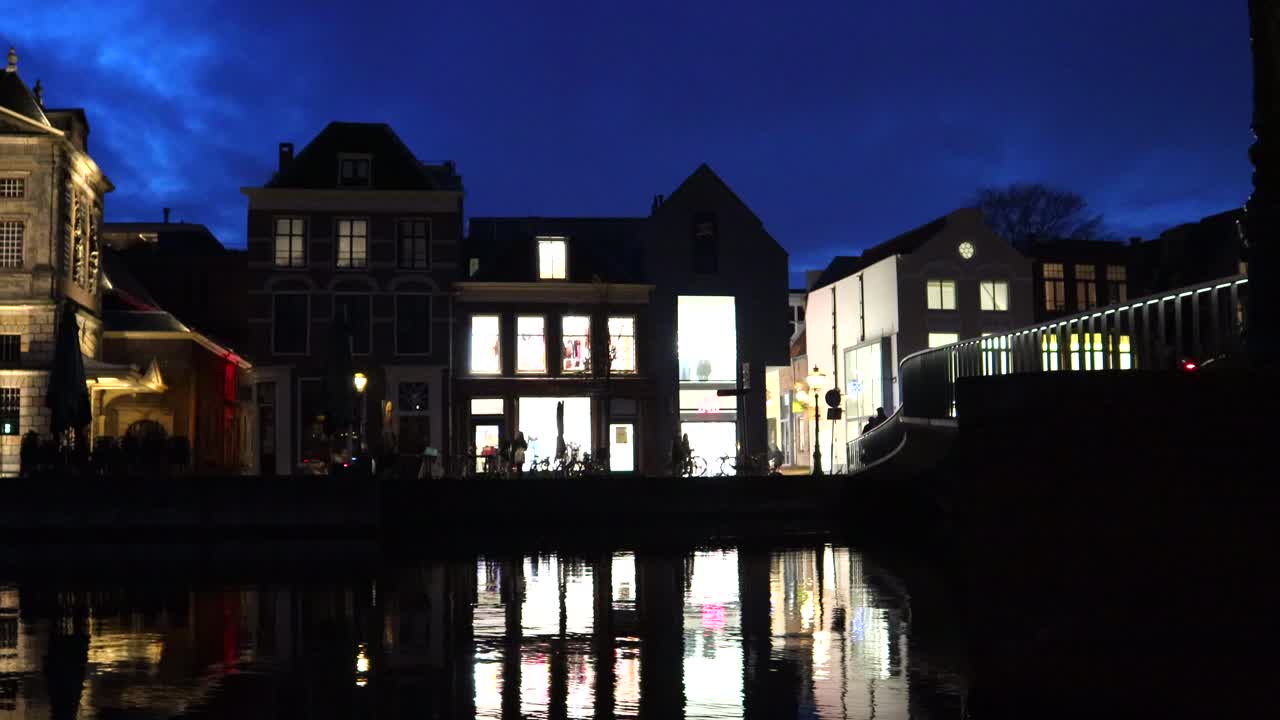 네덜란드 리덴에서 라인 강을 가로지르는 보행자 다리를 지나가는 사람들, 밤, 타임스