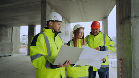 una joven arquitecta y dos capataces profesionales están discutiendo el plan de construcción de un edificio residencial