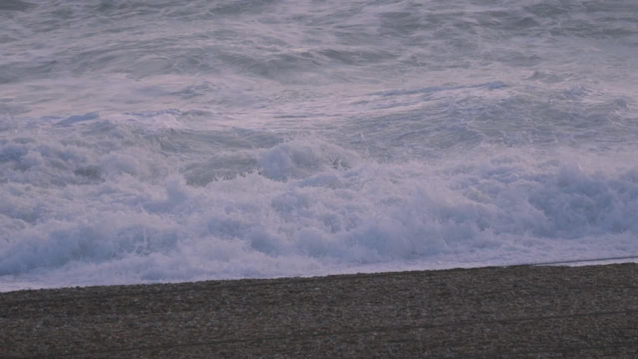 Big Slow Motion Wave Crashing on Pebble Beach in Slow Motion in Golden Hour Sunset Light