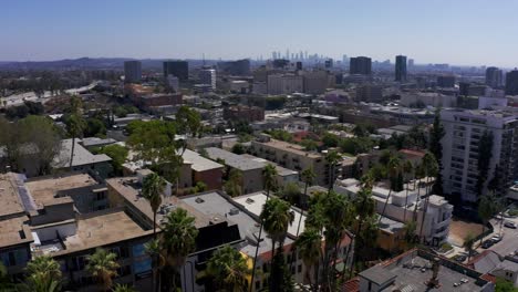 Toma-Aérea-Panorámica-Baja-De-Hollywood-Y-La-Autopista-101-Con-El-Centro-De-Los-Ángeles-Al-Fondo