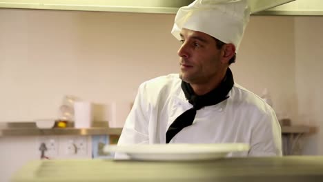 Handsome-chef-putting-away-plates