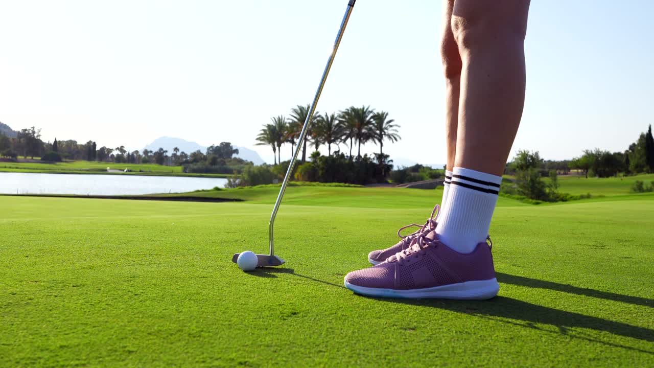 A golfer putting on a green golf course