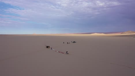 aerial view of some men getting ready to launch a balloon in the desert