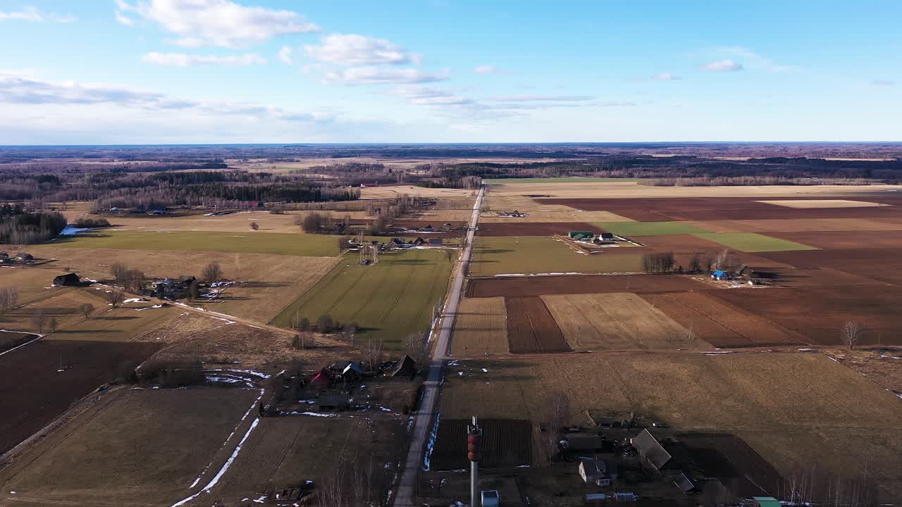 Majestic small town and farmlands in horizon in aerial drone shot