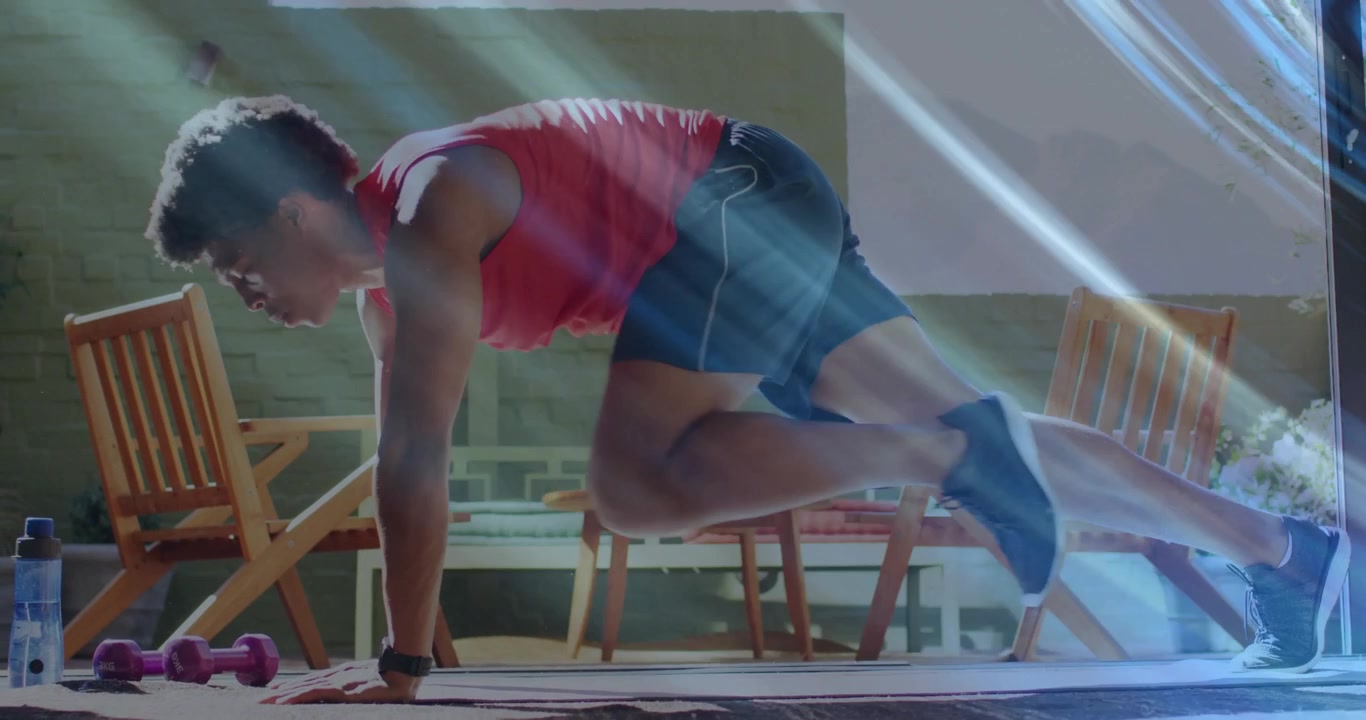 Appassionato di fitness che si posiziona in plank sul tappetino, iniziando i mountain climbers per il rafforzamento del core.