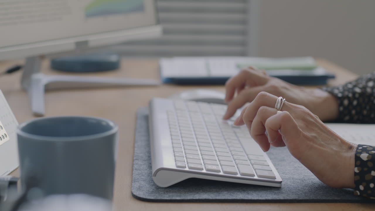 Woman Typing on a Keyboard in an Office
