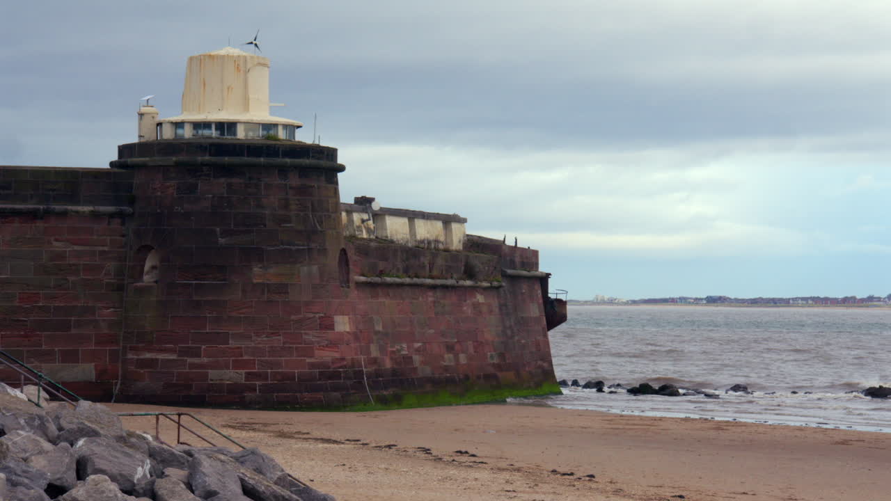 Bild av en del av Fort Perch Rock vid floden Mersey en molnig dag vid New Brighton-stranden.