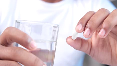 person taking medication with water