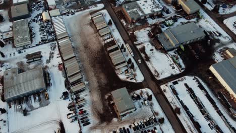 aerial shot of a lone semi-truck driving in an industrial area among warehouses