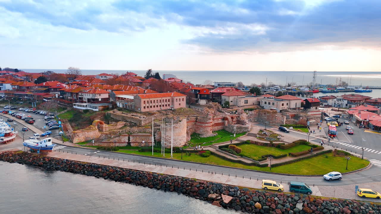 Vista de Drone de Antigos Muros de Fortificação e Ruínas de Pedra. Restos de Fortaleza Medieval de Pedra Situados em uma Área Gramada Dentro de um Assentamento Costeiro