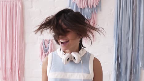 slow motion footage of a yong brunette girl having fun, shaking her head and shouting. indoors