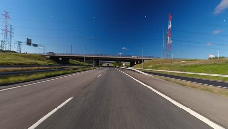 pov blue sky drive through several overpasses on suburban highway