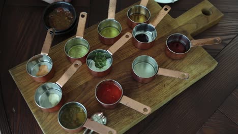 variety of sauces and dips on a wooden board