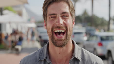 portrait of handsome young man laughing cheerful enjoying warm summer vacation satisfaction on busy urban beachfront gorgeous caucasian male real people series