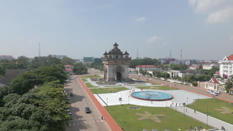 Besucher-Erkunden-Das-Patuxai-Siegesdenkmal-Im-Zentrum-Von-Vientiane,-Laos,-Während-Autos-Vorbeifahren