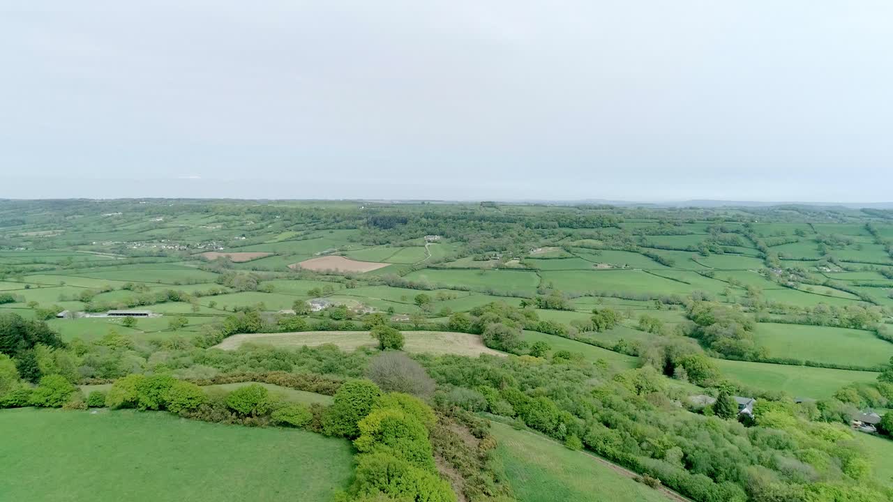 panorama aéreo lento, alto sobre un vasto tapiz de tierra verde fértil en europa occidental