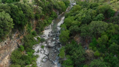 4K-AERIAL-DOLLY-IN:-Drone-flying-above-Alcantara-Gorges,-an-impressive-channel-of-lava-columns-eroded-naturally-into-ravines,-canyons-and-caves