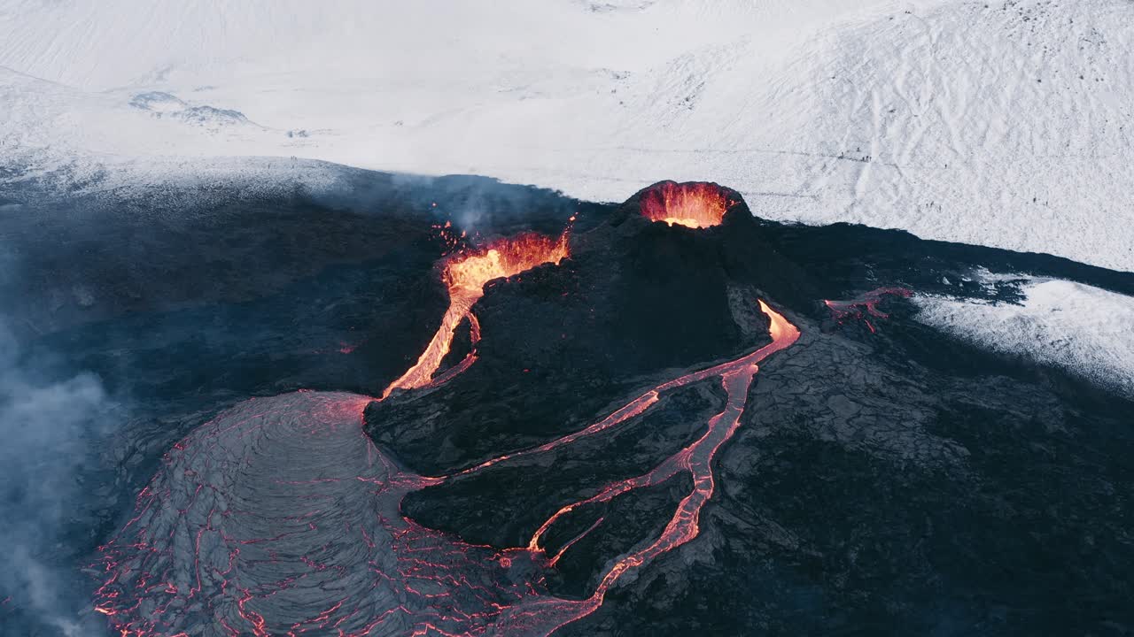 Gunung berapi meletus di lanskap terpencil Islandia dengan pegunungan bersalju, dari udara
