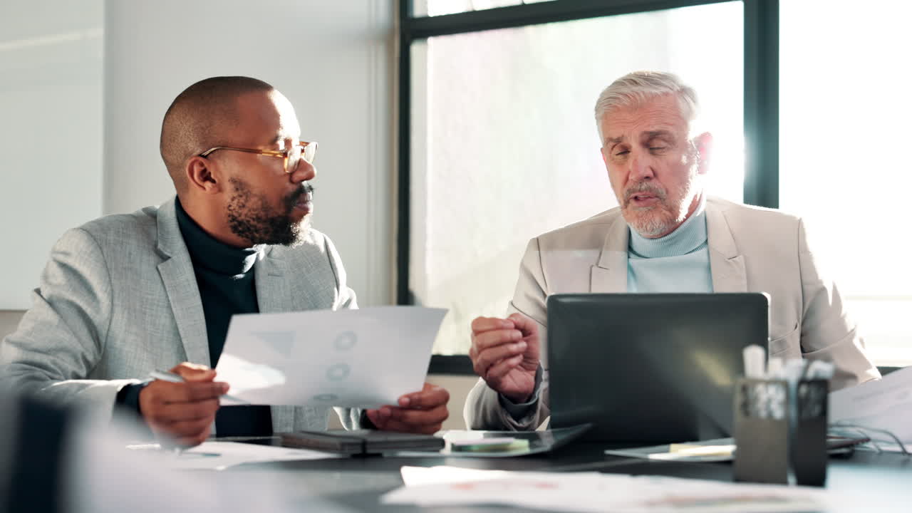 Two businessmen discussing data in a meeting