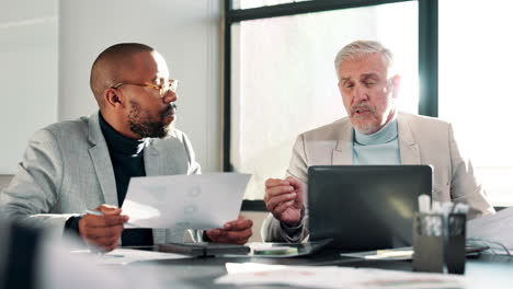 two businessmen discussing data in a meeting