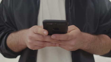 male hands messaging on smartphone.