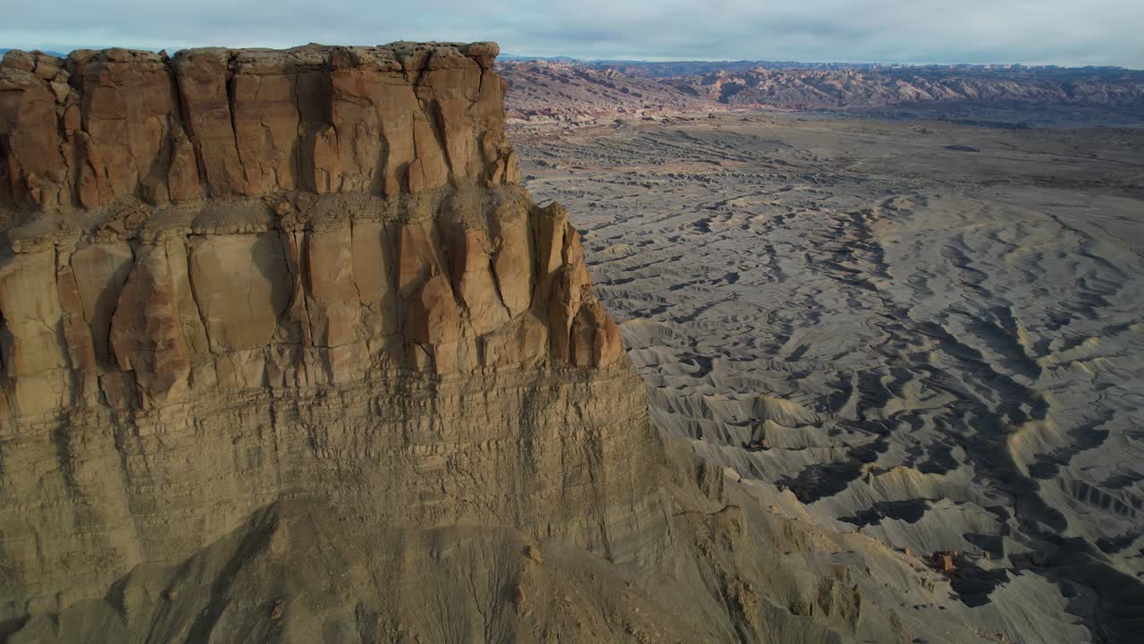 Aerial View of Dry Barren Gray Sandstone Patterns and Desert Landscape Under Factory Butte, Utah USA