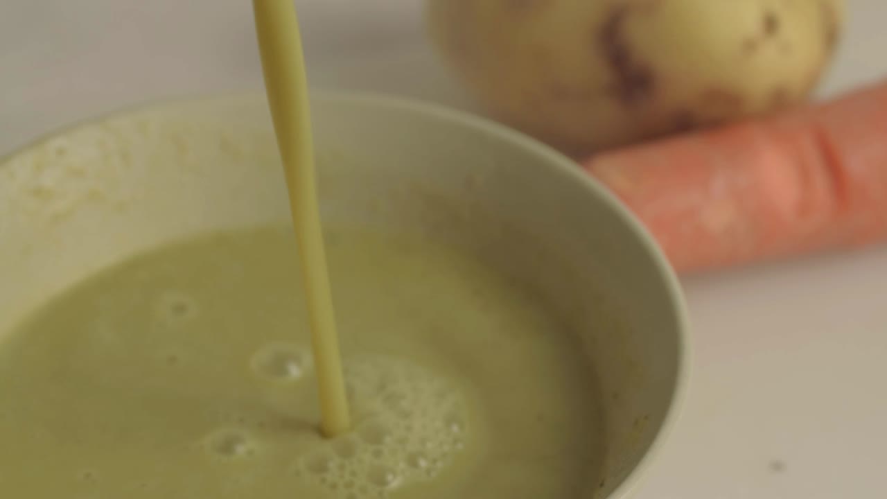 Pouring healthy vegetable soup into a bowl close up