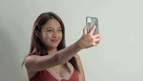 latina girl joyfully taking a selfie, displaying happiness and fun while capturing special moments with her mobile phone